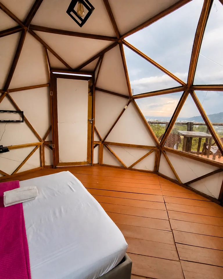 Interior del domo con cama y vista de montaña en La Cumbre de los Molinos.